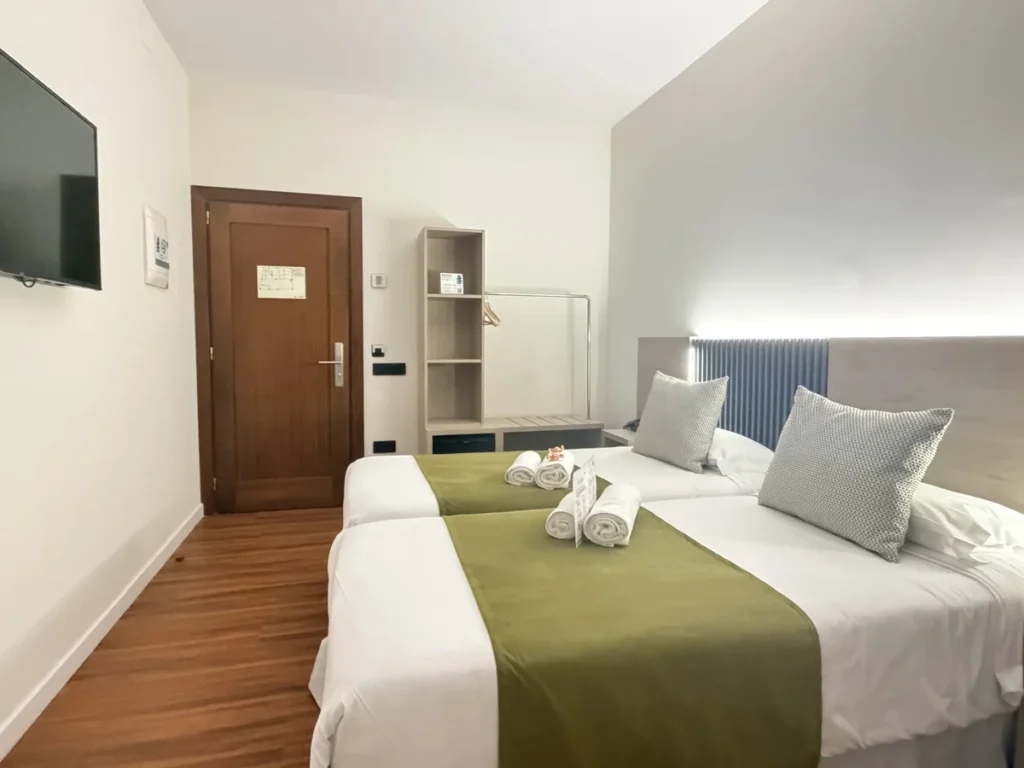Habitación 101 adaptada con espacio amplio de paso entre la cama y la pared, televisión y puerta