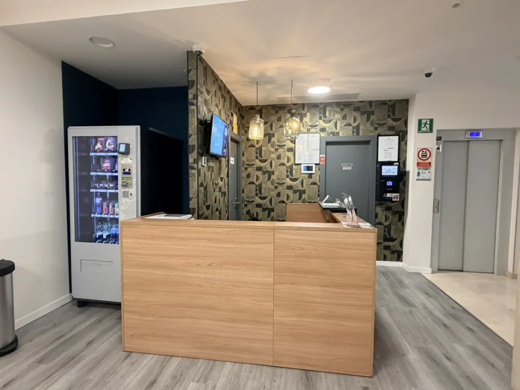 Mostrador de madera de la recepción, máquina vending y ascensor en la planta baja de SAHERA